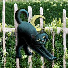 Load image into Gallery viewer, Black cat figurine on a wooden fence with greenery in the background