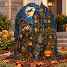 Load image into Gallery viewer, A large Halloween yard sign featuring a witch, a haunted house, a black cat, pumpkins, and autumn foliage, displayed outdoors in front of a house entrance.