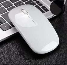 Load image into Gallery viewer, White computer mouse on a black textured surface with a laptop in the background