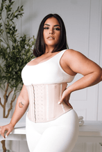 Load image into Gallery viewer, Woman wearing a white compression garment in a minimal indoor setting