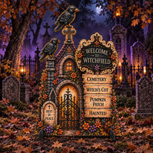 Load image into Gallery viewer, Halloween decorative tombstone sign shaped like a small gothic graveyard with a gate, crosses, flowers, crows, and a sign reading “Welcome to Witchfield” and “Cemetery Witch’s Cot Pumpkin Patch Haunted,” shown in a spooky cemetery setting.
