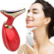 Load image into Gallery viewer, Woman demonstrating a white LED neck massager under her chin beside a red device
